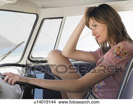 Young woman sitting in drivers seat of van, close up View Large Photo Image Picture - Young woman sitting in drivers seat of van, close up. Fotosearch