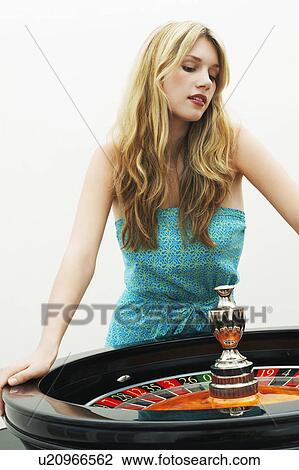 Young woman standing at roulette wheel View Large Photo Image Stock Image - Young woman standing at roulette wheel. Fotosearch