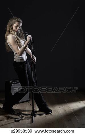 Young woman with microphone, portrait View Large Photo Image Stock Photo - Young woman with microphone, portrait. Fotosearch