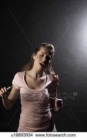 Young woman with mp3 player singing in studio View Large Photo Image Picture - Young woman with mp3 player singing in studio. Fotosearch