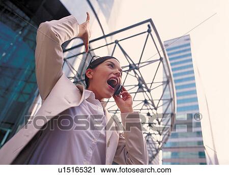 Stock Image - day time, posing, talking, standing, cellular, facial expression. Fotosearch