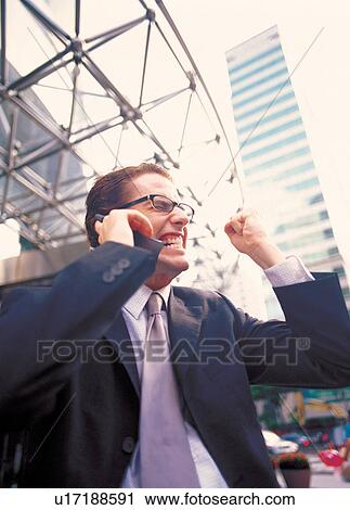 Stock Image - posing, excited, suit, holding, facial, shine. Fotosearch