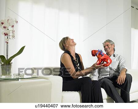 Stock Photo - A woman laughing at a gift. Fotosearch
