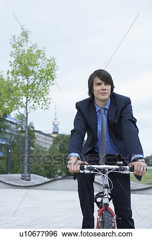 Stock Photograph - Businessman on bike laughing.. Fotosearch