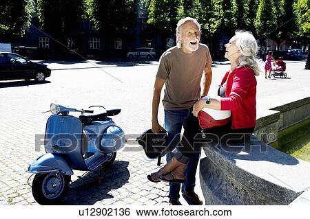 Couple having a break with scooter View Large Photo Image Stock Photograph - Couple having a break with scooter. Fotosearch