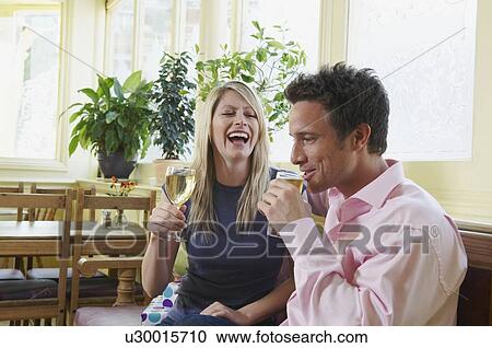 Stock Image - Couple in pub enjoy a drink. Fotosearch