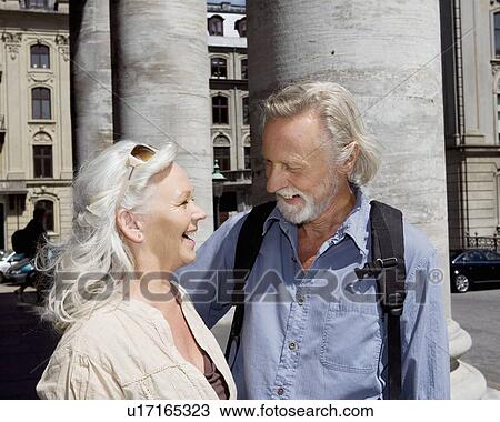 Stock Image - Couple standing laughing. Fotosearch