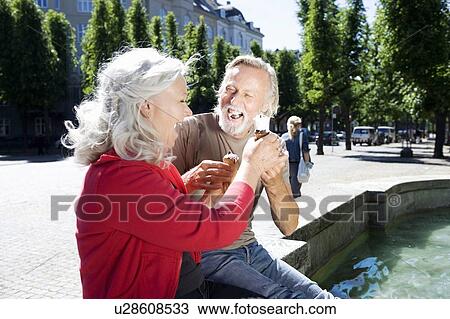 Couple with ice-cream, laughing View Large Photo Image Stock Image - Couple with ice-cream, laughing. Fotosearch
