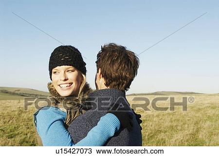 Stock Image - Embracing couple in countryside. Fotosearch