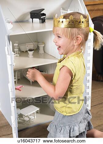 Little girl playing with a doll house View Large Photo Image Stock Photo - Little girl playing with a doll house. Fotosearch
