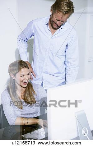 Man and women in office at computer. View Large Photo Image Stock Photo - Man and women in office at computer.. Fotosearch