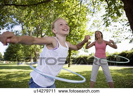Stock Image - Mother and daughter with hula-hoop. Fotosearch