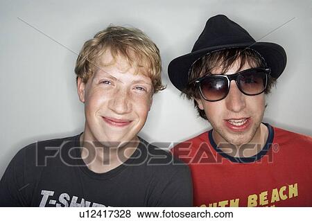 Stock Photo - Two young males one wearing glasses and hat. Fotosearch