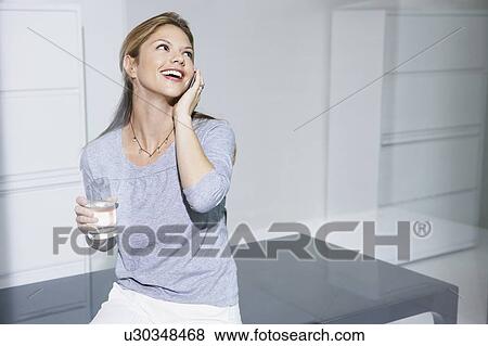 Woman on computer desk on cell phone. View Large Photo Image Stock Photo - Woman on computer desk on cell phone.. Fotosearch