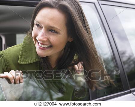 Picture - Woman passing her head out of the car. Fotosearch