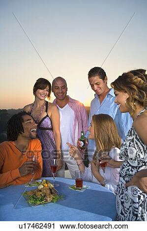 Young people having dinner at sunset View Large Photo Image Stock Image - Young people having dinner at sunset. Fotosearch