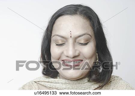 Stock Image - Close-up of a mature woman with her eyes closed smiling. Fotosearch