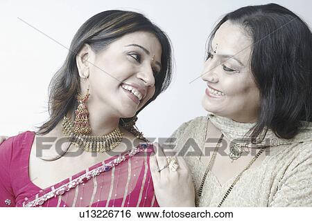 Close-up of a mid adult woman with a mature woman looking at each other View Large Photo Image Stock Photograph - Close-up of a mid adult woman with a mature woman looking at each other. Fotosearch