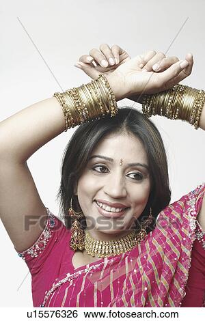 Stock Photograph - Close-up of a mid adult woman with her hands above her head. Fotosearch