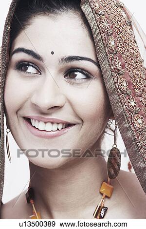 Close-up of a young woman in traditional clothing smiling View Large Photo Image Stock Photo - Close-up of a young woman in traditional clothing smiling. Fotosearch