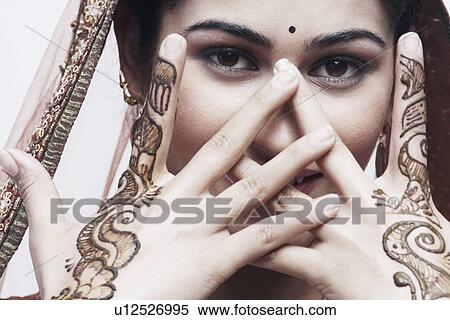 Stock Photography - Close-up of a young woman with henna tattoo's on her hands. Fotosearch