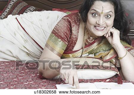Portrait of a mature woman clenching her teeth lying on the bed View Large Photo Image Stock Photo - Portrait of a mature woman clenching her teeth lying on the bed. Fotosearch
