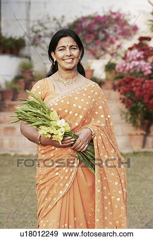 Stock Photo - Portrait of a mature woman holding a bunch of flowers. Fotosearch
