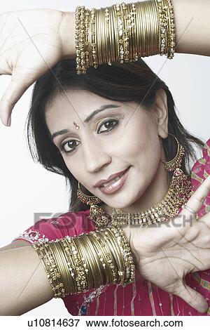 Stock Photo - Portrait of a mid adult woman showing her bangles. Fotosearch