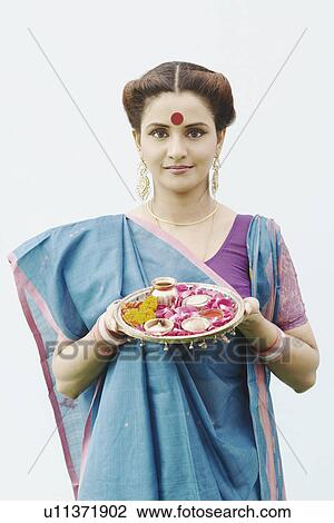 Portrait of a young woman holding a plate of religious offerings View Large Photo Image Stock Image - Portrait of a young woman holding a plate of religious offerings. Fotosearch
