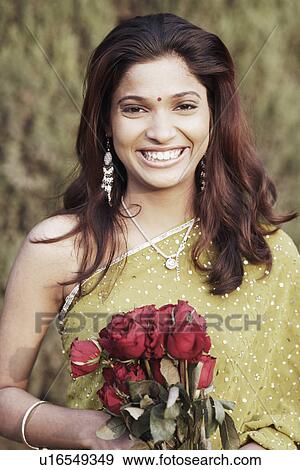 Portrait of a young woman holding a bunch of roses View Large Photo Image Stock Photo - Portrait of a young woman holding a bunch of roses. Fotosearch