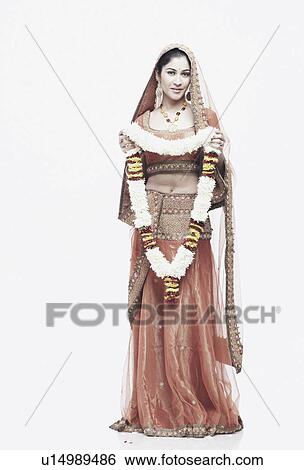 Stock Photograph - Portrait of a young woman in traditional clothing holding a garland. Fotosearch