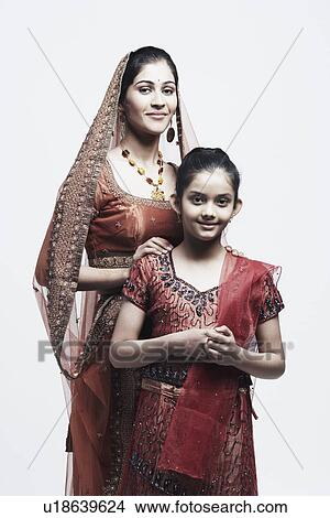 Picture - Portrait of a young woman standing behind her sister. Fotosearch