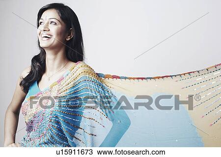Stock Image - Young woman standing with arms akimbo. Fotosearch