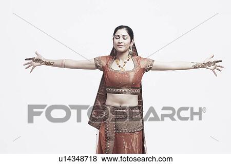Young woman standing with her eyes closed and her arms outstretched View Large Photo Image Stock Photo - Young woman standing with her eyes closed and her arms outstretched. Fotosearch
