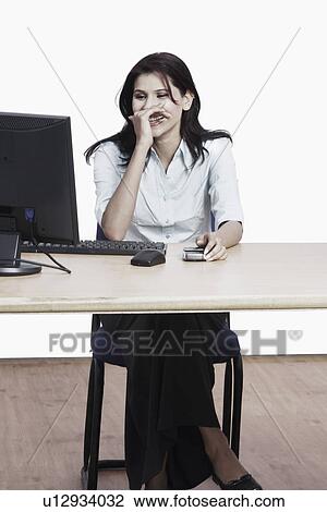 Businesswoman sitting in front of a computer View Large Photo Image Stock Image - Businesswoman sitting in front of a computer. Fotosearch