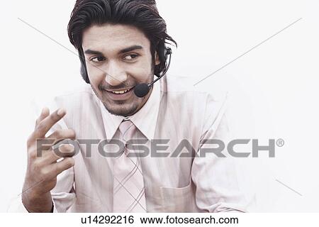 Stock Photograph - Close-up of a businessman wearing a hands free device. Fotosearch