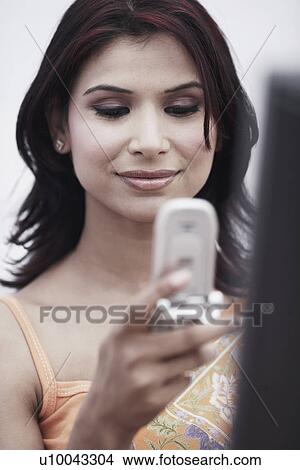 Close-up of a businesswoman holding a mobile phone View Large Photo Image Picture - Close-up of a businesswoman holding a mobile phone. Fotosearch