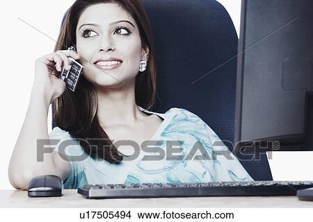 Picture - Close-up of a businesswoman talking on a mobile phone. Fotosearch