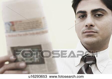 Portrait of a businessman holding a newspaper View Large Photo Image Stock Image - Portrait of a businessman holding a newspaper. Fotosearch
