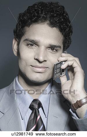 Portrait of a businessman holding a mobile phone View Large Photo Image Stock Photo - Portrait of a businessman holding a mobile phone. Fotosearch