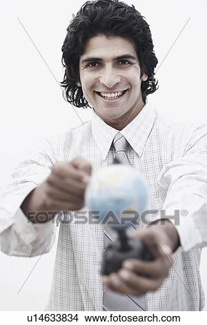 Portrait of a businessman pointing to a globe View Large Photo Image Picture - Portrait of a businessman pointing to a globe. Fotosearch