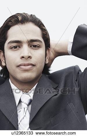 Stock Image - Portrait of a businessman relaxing with his hands behind his head. Fotosearch