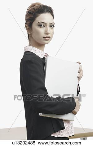 Portrait of a businesswoman holding a laptop View Large Photo Image Stock Photography - Portrait of a businesswoman holding a laptop. Fotosearch