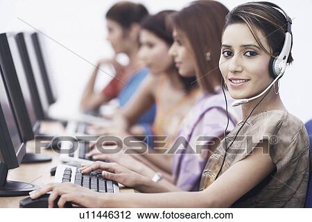 Stock Image - Portrait of a businesswoman sitting in front of a computer. Fotosearch