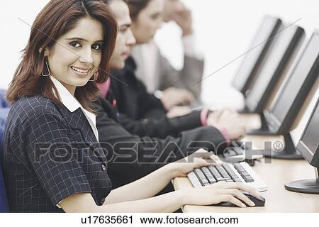 Stock Image - Portrait of a businesswoman sitting in front of a computer. Fotosearch