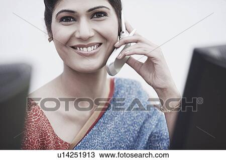 Stock Image - Portrait of a businesswoman talking on a mobile phone. Fotosearch