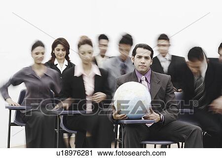Stock Image - Portrait of a group of business executives sitting in a meeting. Fotosearch