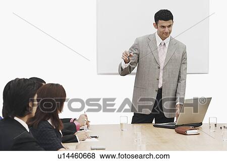 Stock Photo - Businessman giving a presentation in a meeting. Fotosearch