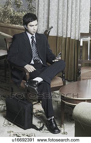 Businessman looking at a mobile phone View Large Photo Image Stock Image - Businessman looking at a mobile phone. Fotosearch