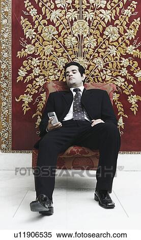 Businessman looking at a mobile phone View Large Photo Image Stock Photography - Businessman looking at a mobile phone. Fotosearch